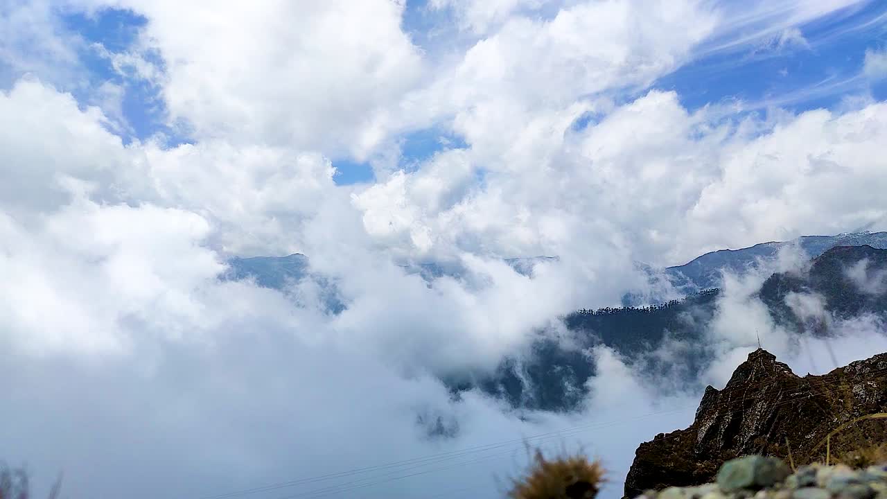 아침에 평평한 각도에서 히말라야 산을 배경으로 무거운 구름 움직임이 인도 셀라 패스 타왕에서 촬영됩니다.