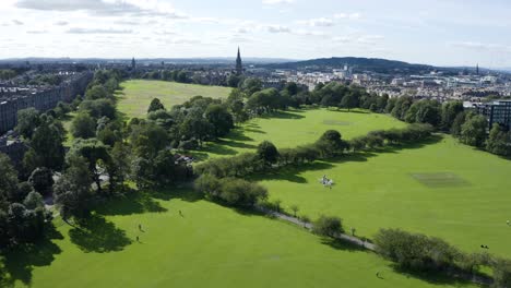 An-aerial-shot-moving-across-the-meadows-in-Edinburgh,-on-a-sunny-Summer-day