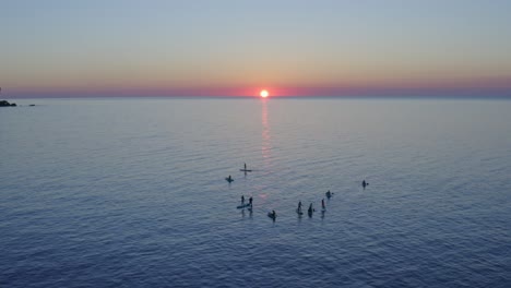 Silhouette-Von-Paddle-Boardern,-Die-Bei-Sonnenuntergang-In-Den-Gewässern-Von-Menorca-Schwimmen