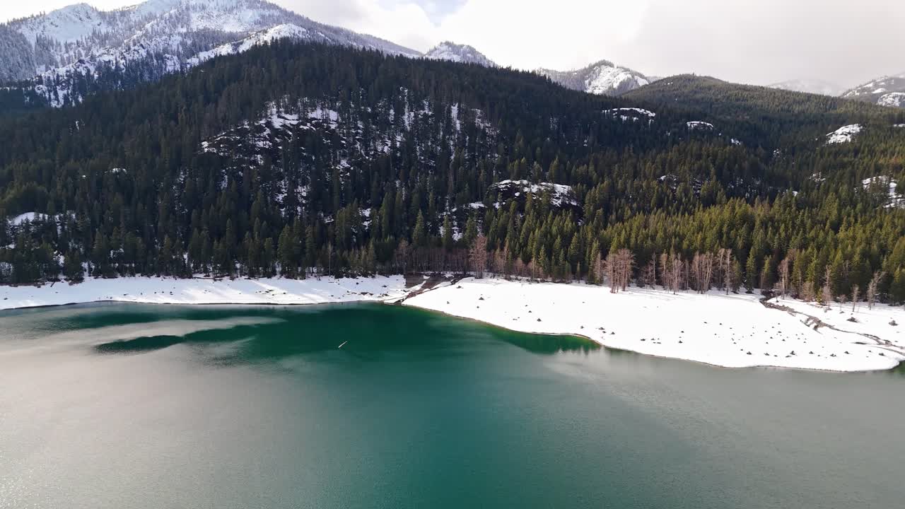 hermosa vista aérea del lago kachess con bancos de nieve y siempre verdes con montañas cubiertas de nieve en el estado de washington