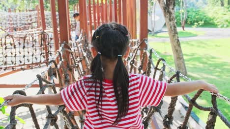 active little sisters having fun in the outdoor playground in the park. cute little girls climbing and sliding down on children playground. play is learning in childhood.