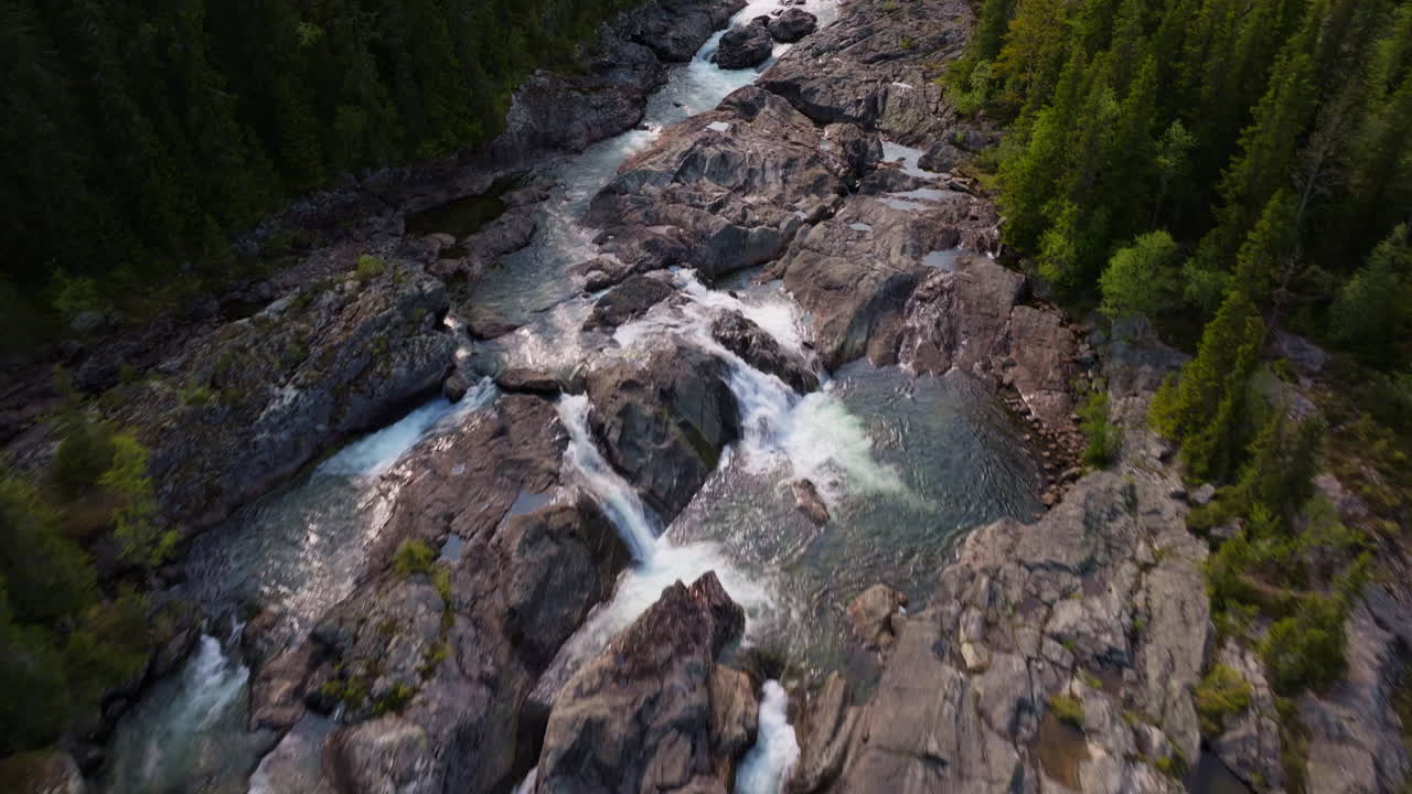 Aerial view of drone flying over a river in Norway surrounded by forest
