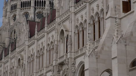 Fachada-De-Estilo-Neogótico-Del-Edificio-Del-Parlamento-Húngaro-En-Budapest,-Inclinada-Hacia-Arriba