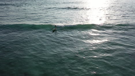 a paddleboarder surfs a wave on a on sup board in the ocean in the waters of reunion island