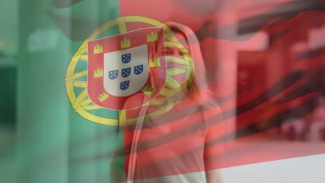 animation of flag of portugal waving over woman wearing face mask during covid 19 pandemic