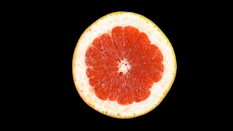 ripe grapefruit in the section slowly rotates around its axis. isolated on a white background.