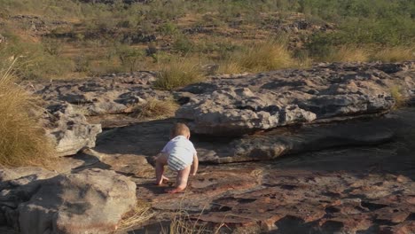 a toddler crawling in the rocky outdoors developing their motor skills