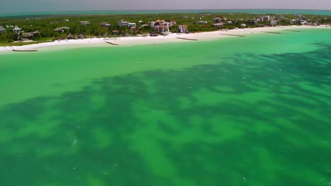 Aufschlussreiche-Drohnenaufnahme-Mit-Schwenk-Von-Der-Küste,-Um-Das-Türkisfarbene-Wasser-Der-Insel-Holbox-Zu-Präsentieren