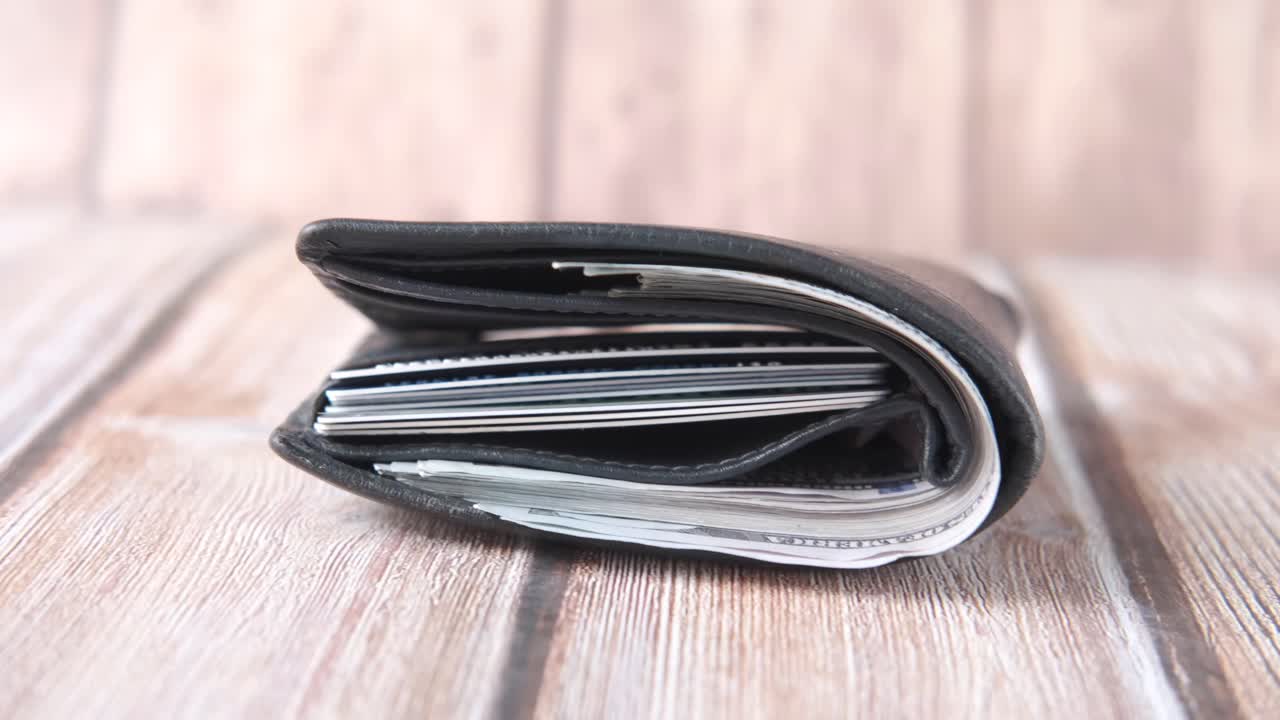 현금과 신용카드가 들어있는 검은색 가죽 지갑