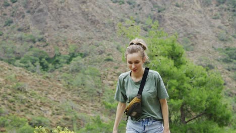 Woman-stands-alone-on-the-mountain-high,-enjoying-the-view