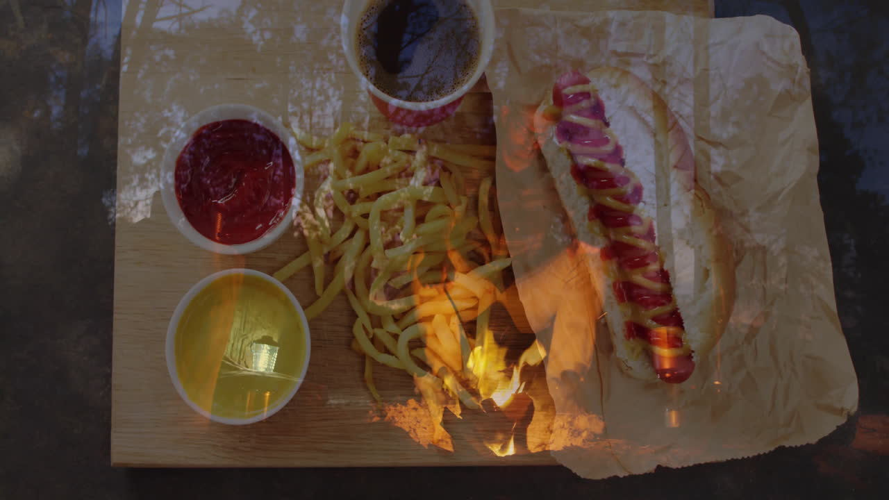 Hot dog with mustard and ketchup served with fries and drinks on board