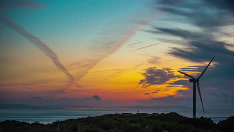 wind turbine above the strait of gibraltar, spain generates renewable energy - sunset time lapse