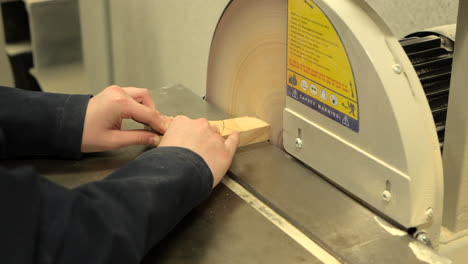 student using a disc sanding machine in woodwork class, close up