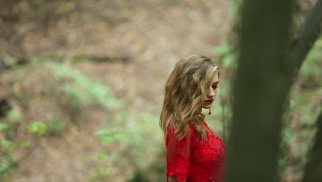 romantisches stilvolles mädchen in langem roten kleid im wald