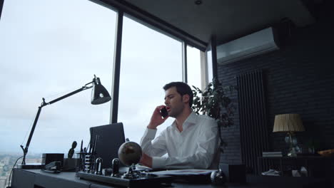 Businessman-working-on-laptop-computer-in-office.-Worker-answering-on-phone-call