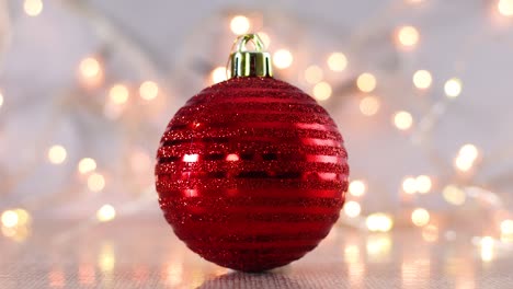 christmas red ornament ball with blinking lights behind