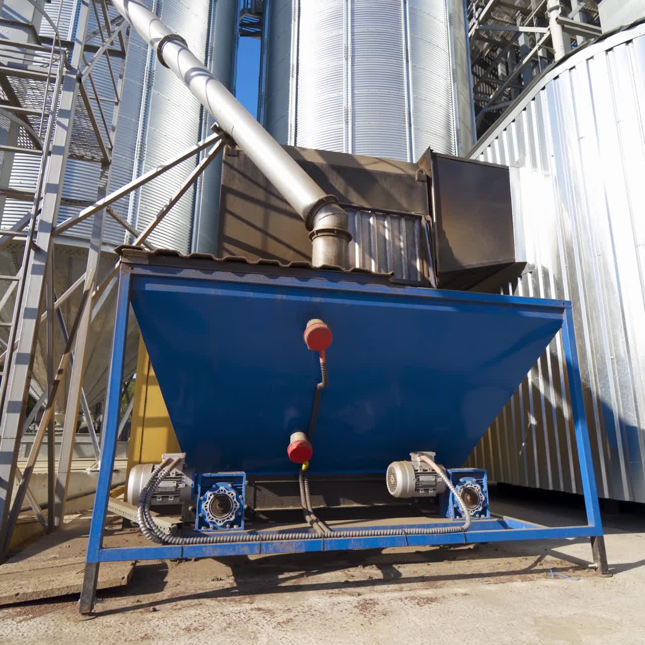 Industrial equipment outdoors. Exterior of modern plant. Large metal grain elevators outdoors. Close-up. Camera moving back