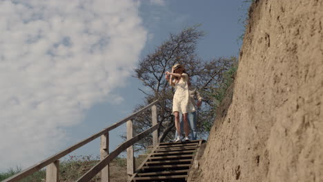 Two-lovers-running-downstairs-seashore-near-hill.-Laughing-woman-outpace-of-guy.