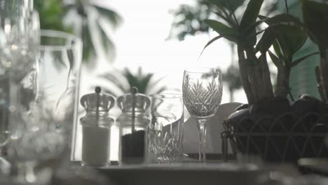 Waiter-setting-table-with-crystal-luxury-glassware,-close-up,-reveal,-truck