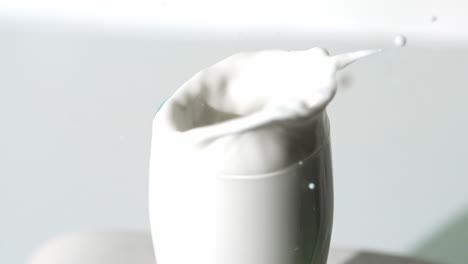 strawberry falling into milk glass