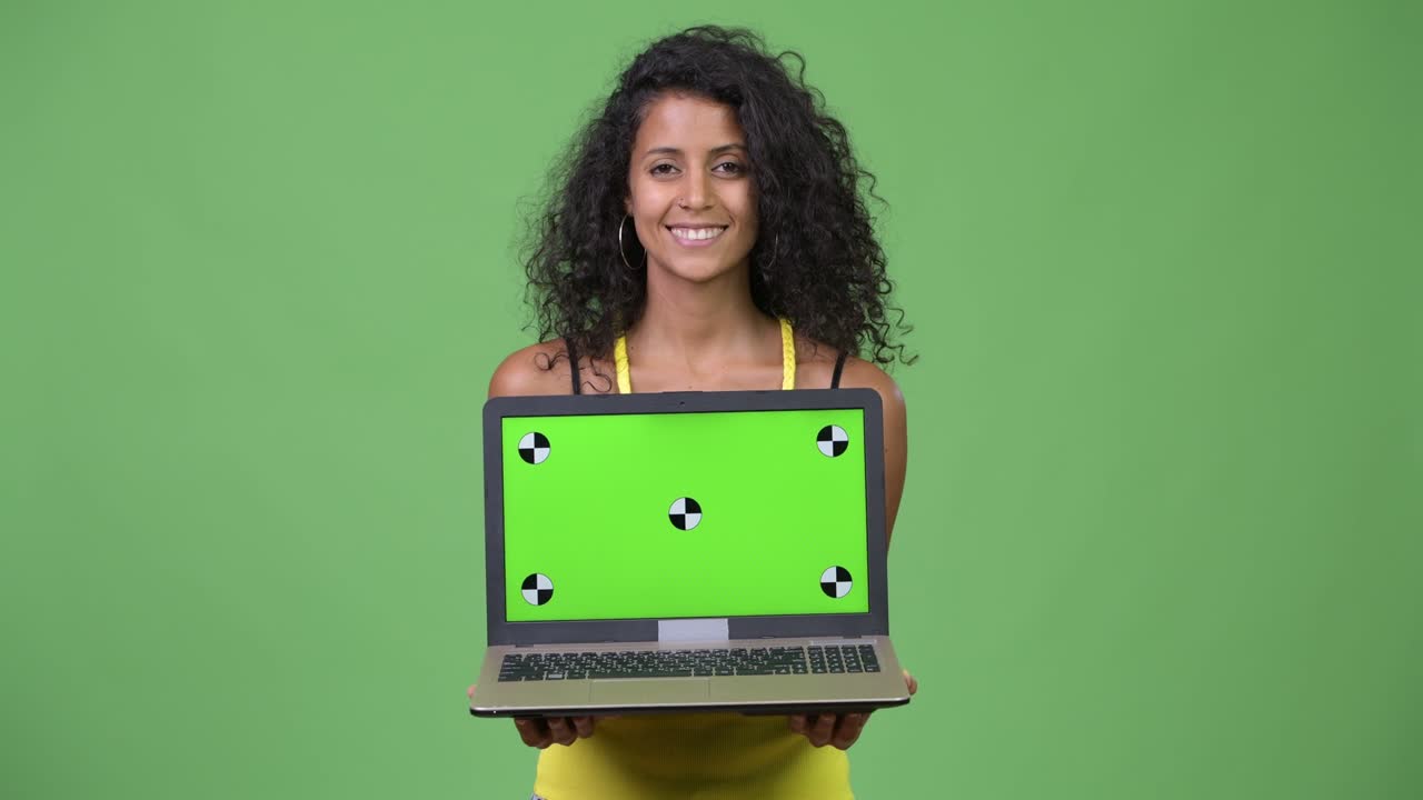 Young beautiful Hispanic woman thinking while showing laptop