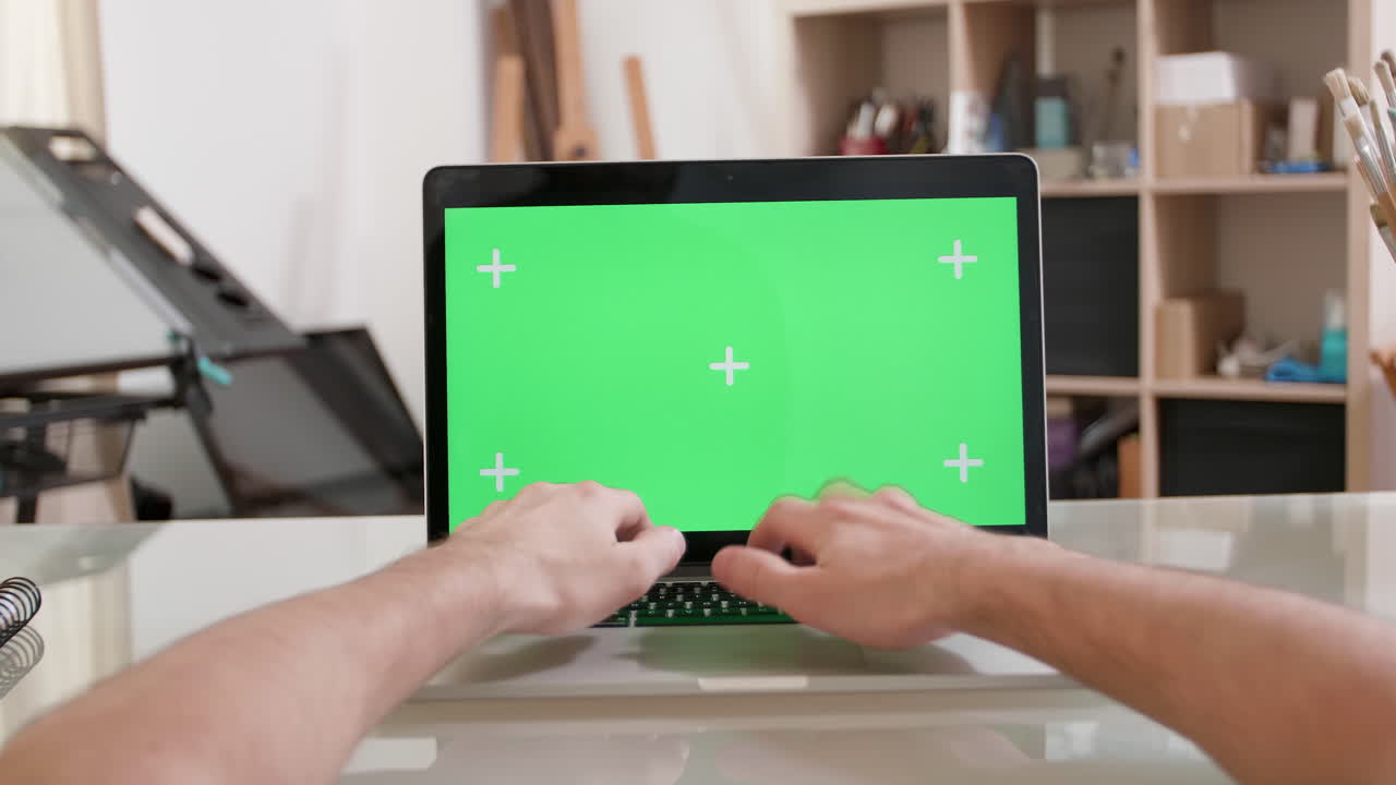 Typing on a laptop with green screen