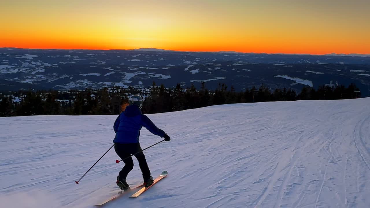 Telemark downhill skier skiing Hafjell Alpine ski resort Øyer mountain Norway Norge vibrant artic sunset golden hour Olympic torch man Lillehammer clear skies groomed trail runs icy packed follow