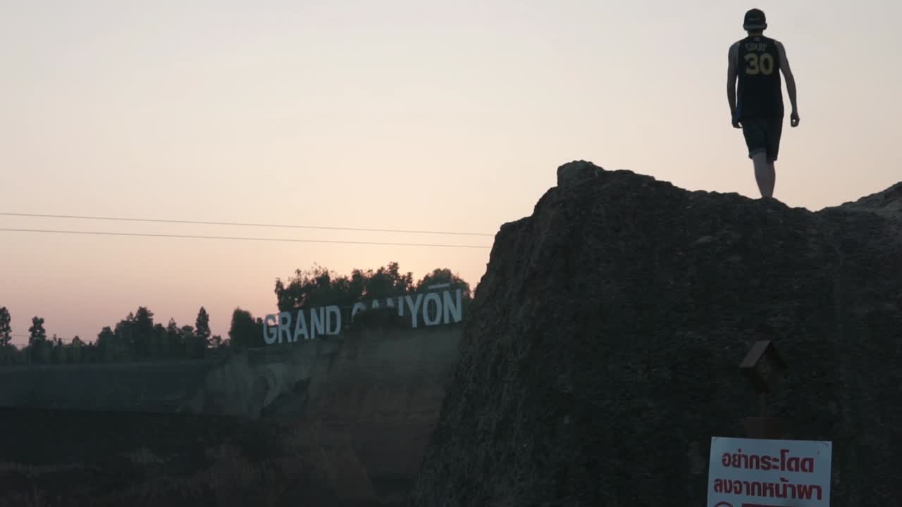 Silhouette of young man on walking on edge of cliff, Krabi Thailand, tilt shot