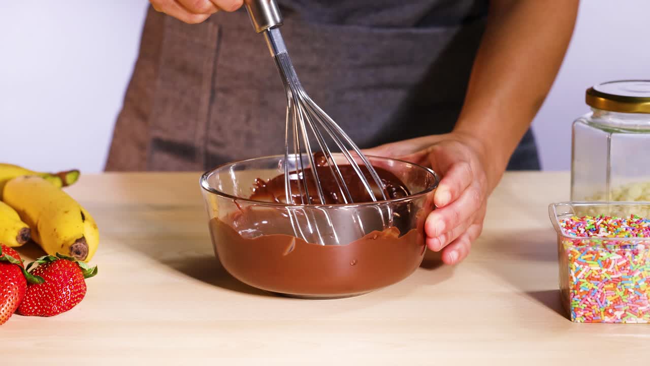 mezclando chocolate con plátanos y fresas cerca