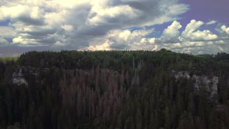 drone footage flying left sideways with lots of clouds in view as the mountain landscape of europe moves by