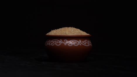 raw white rice in a bowl on black backgroung