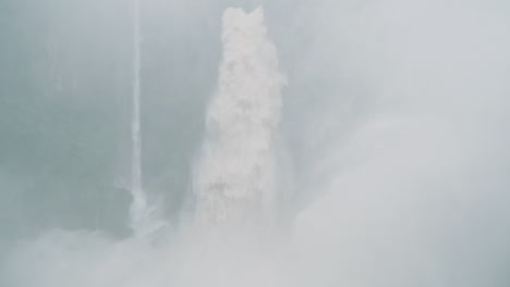 man embraces power of massive jungle waterfall in height of rainy season