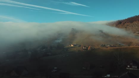 niebla sobre las colinas del pueblo de montaña de sirnea en rumania