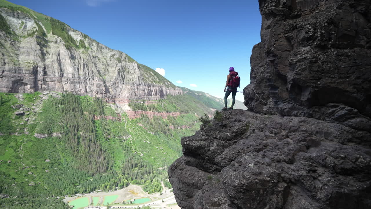 미국 콜로라도의 멋진 풍경 위의 절벽에 서 있는 여성 산악인, 넓은 시야