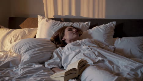 mujer durmiendo en la cama con un libro