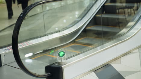 an escalator in motion at a modern shopping mall. the video shows someone climbing on the escalator, captured with a handheld camera, highlighting the details of the moving stairs