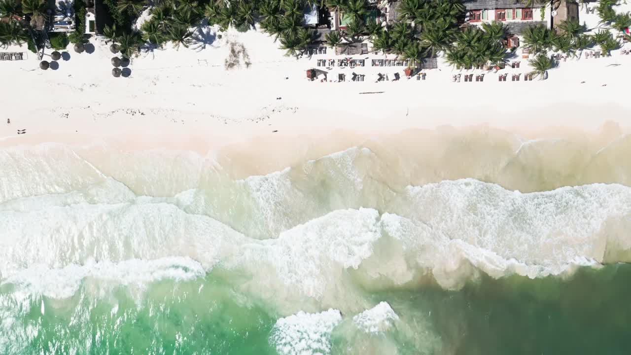 Aerial view of Tulum beach, ocean waves, and palm-lined coast