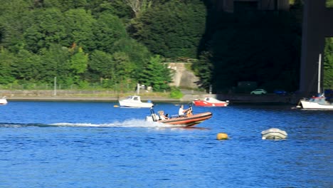 a small dinghy with a motor speeding down the river tamar near saltash in cornwall