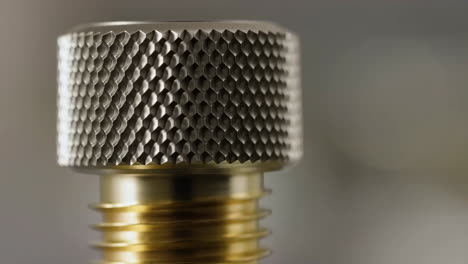 close-up of a knurled metal knob on a brass screw