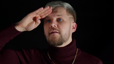 man in stylish blouse looks around with his hand on his forehead, waving hand hi hello welcome bye