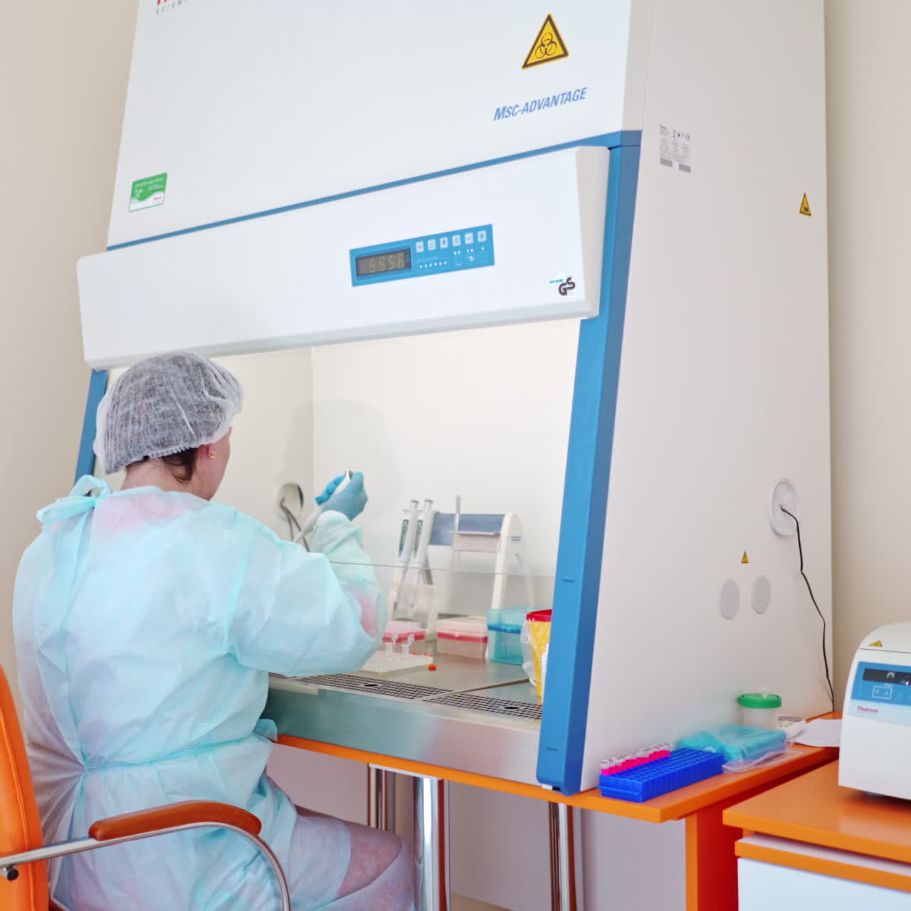 Contemporary laboratory. Medical assistant is working in health center on the background of modern equipment.