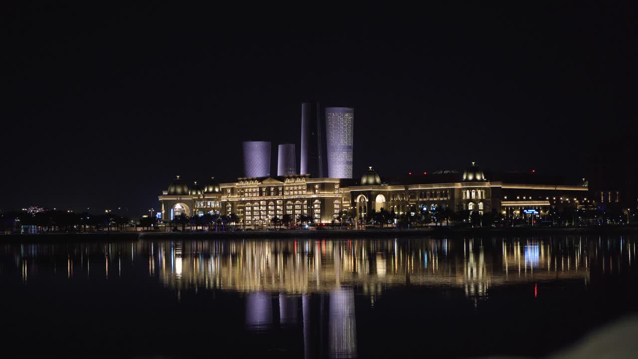 En hisnande nattvy över det storslagna köpcentret Place Vendome och de futuristiska Lusail Plaza Towers som speglar sig perfekt i Qatars lugna marinavatten.