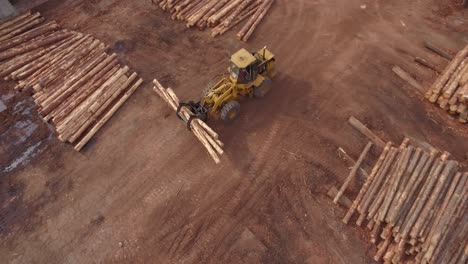 Toma-Aérea-De-4k-Que-Desciende-Hacia-Y-Sigue-El-Vehículo-Cargador-Frontal-De-Tala-De-Madera