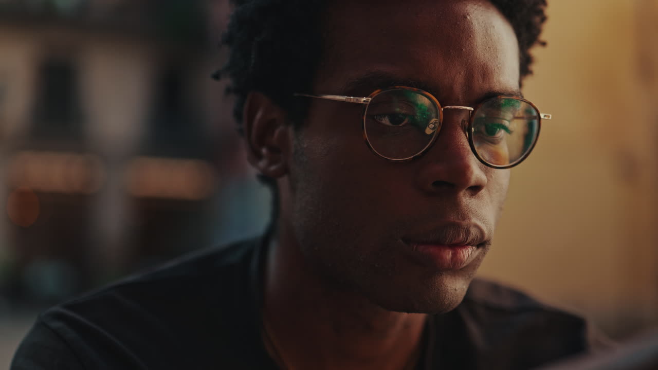 Nahaufnahme eines jungen schwarzen Mannes mit Brille, der sich konzentriert.