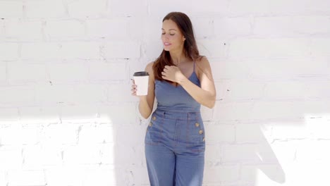 Young-woman-enjoying-a-cup-of-takeaway-coffee