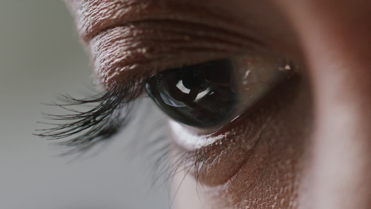 Extreme Close Up of Eye of Scientist Looking through Microscope