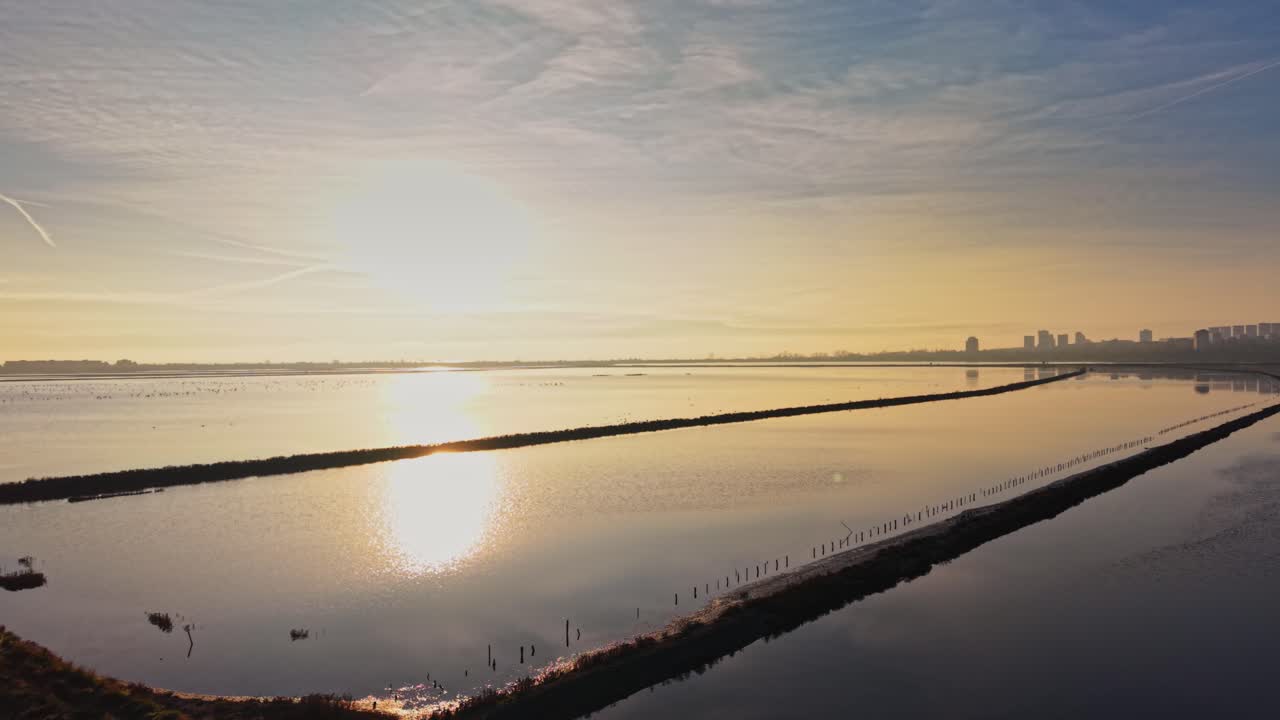 Salt fields and a sunset by the water in a coastal area