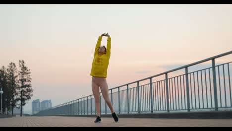 Woman Stretching Outdoors at Sunrise