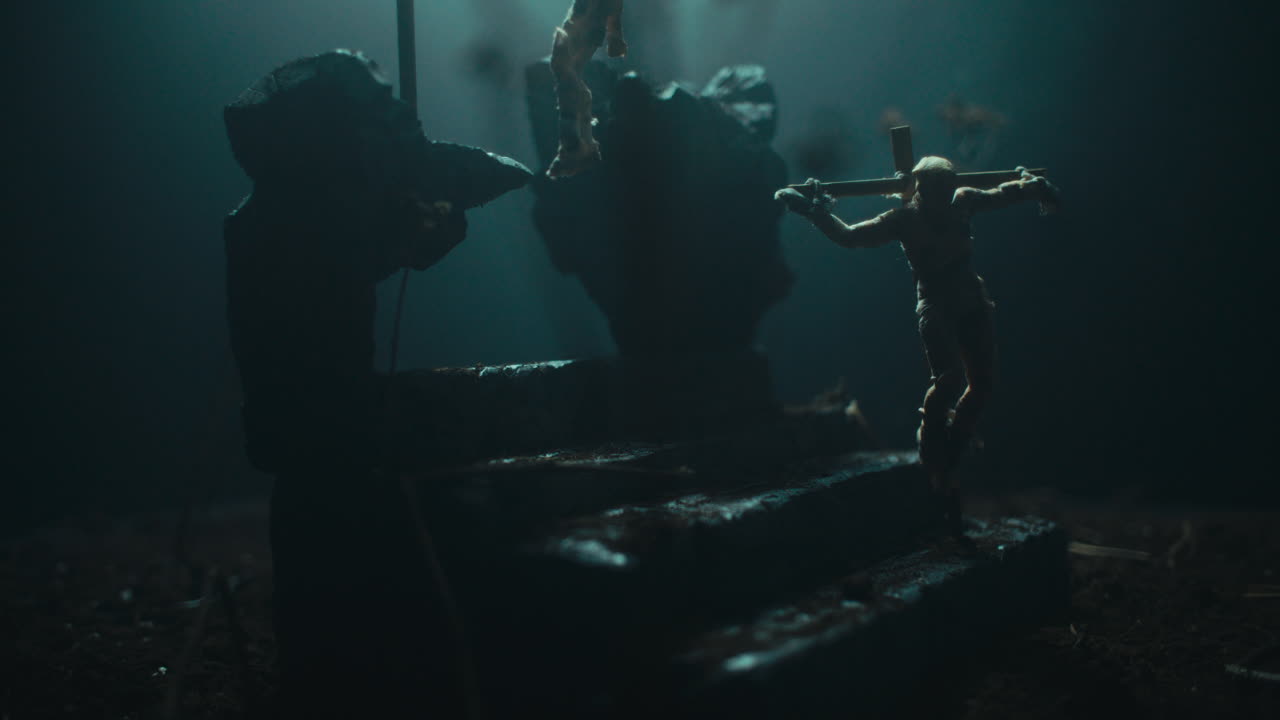 A miniature mummified doll hanging on the gallows at night