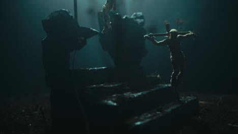 a miniature mummified doll hanging on the gallows at night